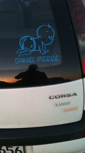 Foto von der Heckscheibe eines Opel Corsa mit einem Kindernamen-Aufkleber
